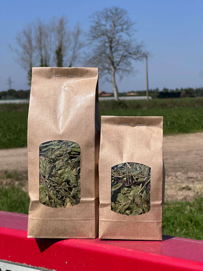 Deux sachets kraft de feuilles séchées naturelles pour rongeurs, posés en extérieur